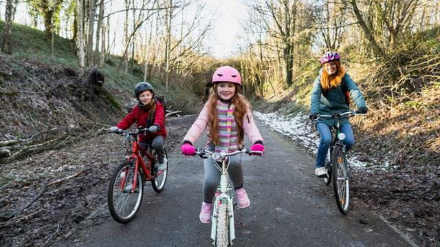 Woman and two children riding bikes in winter